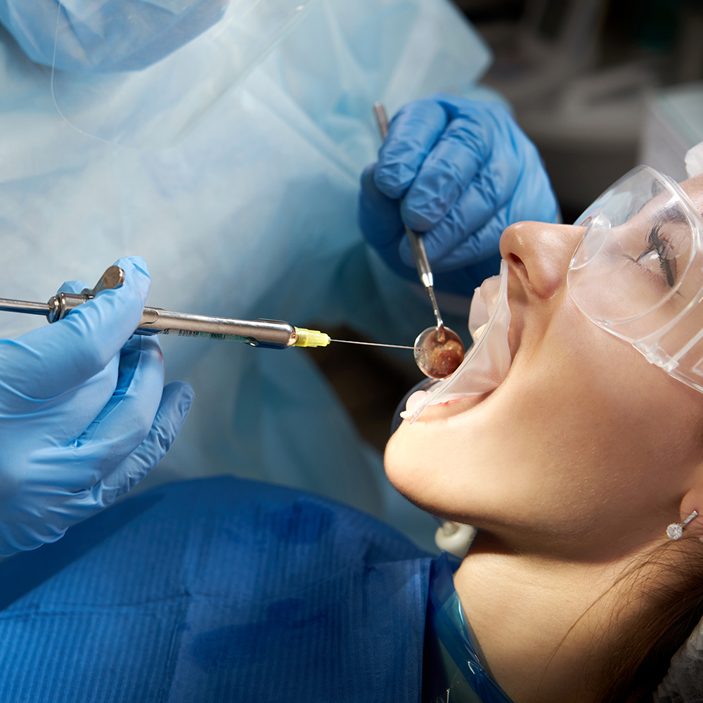 Dentist making local anesthesia shot before surgery. Patient visiting a dental office