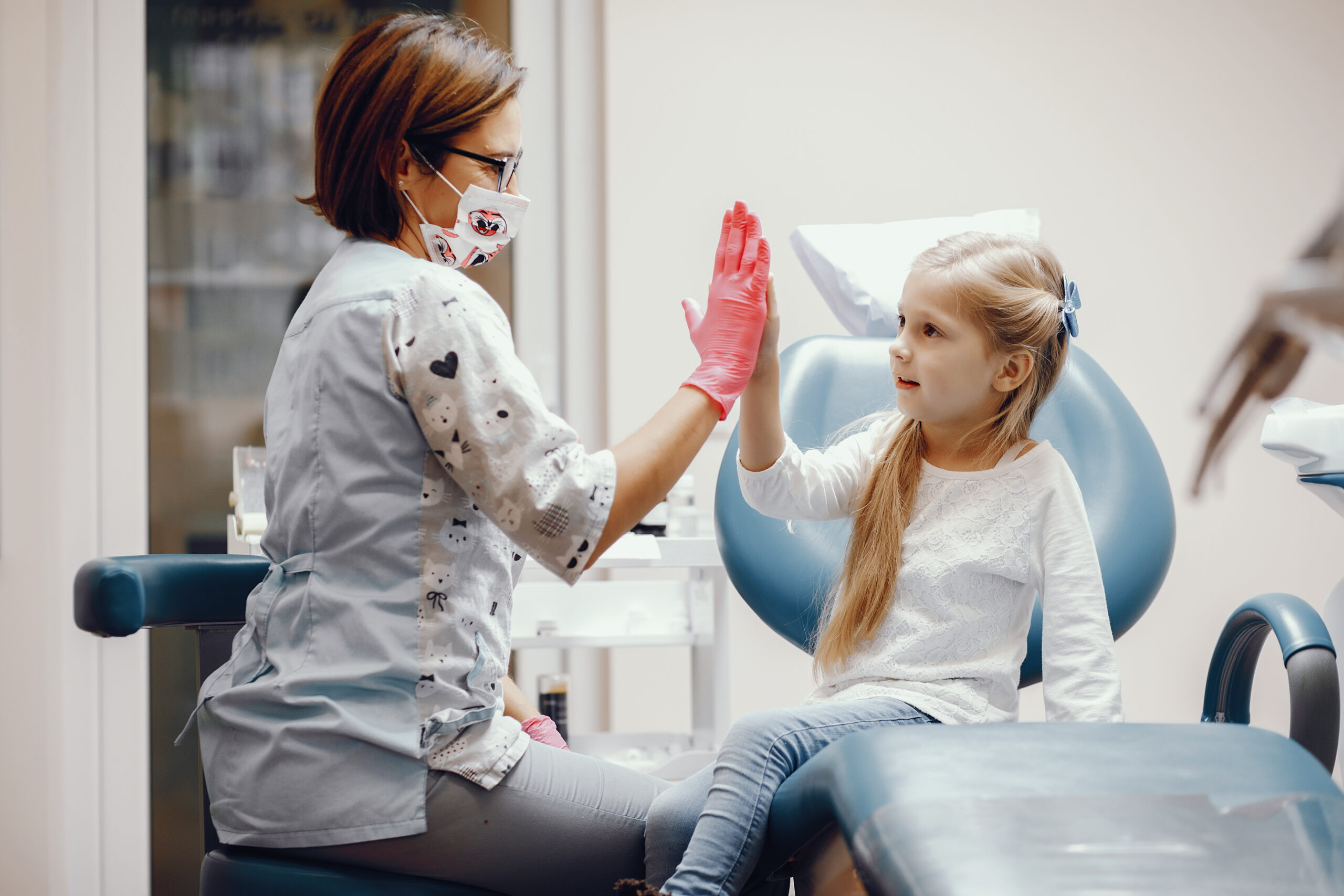 Cute little girl sitting in the dentist's office