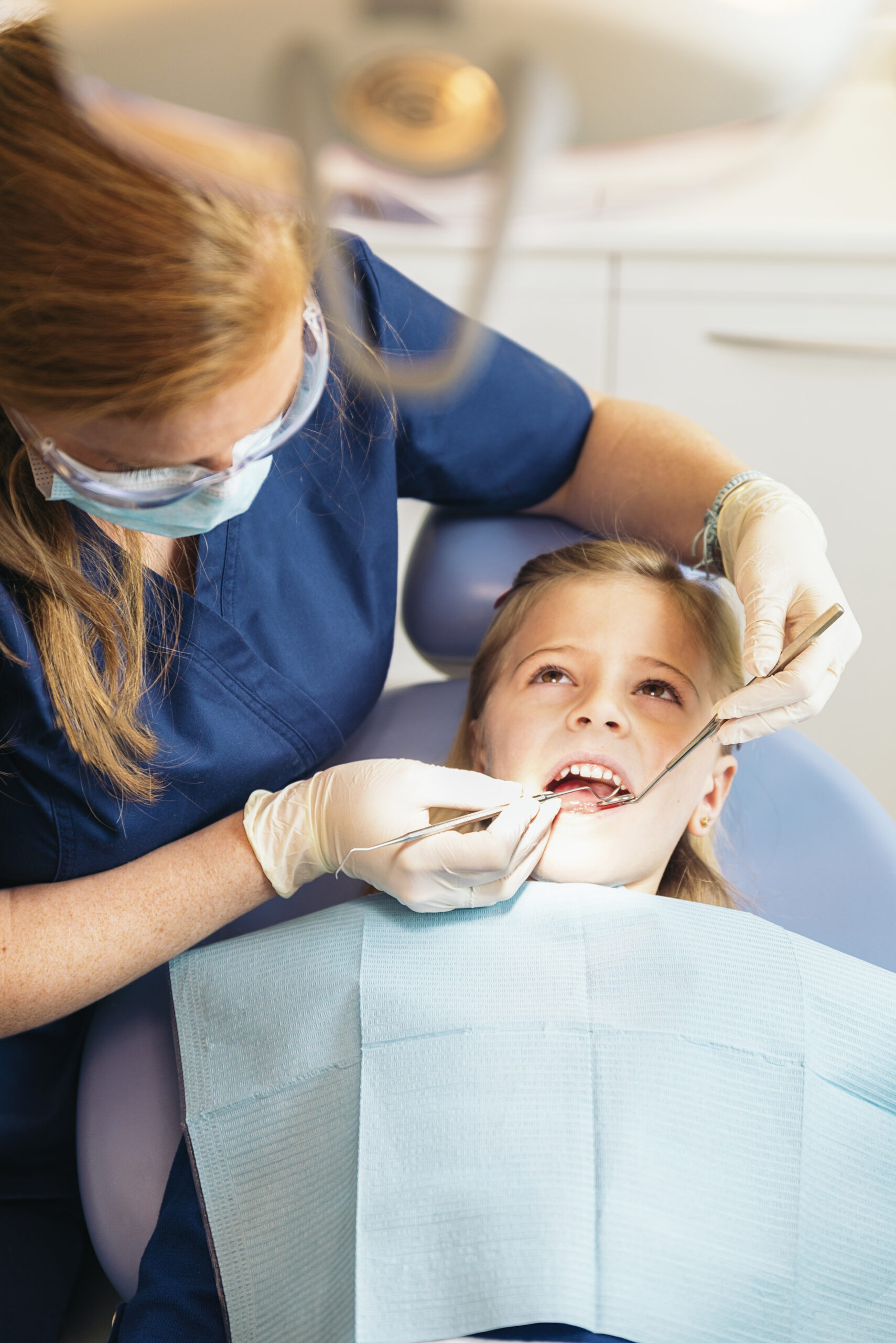 ntists with a patient during a dental intervention to girl.